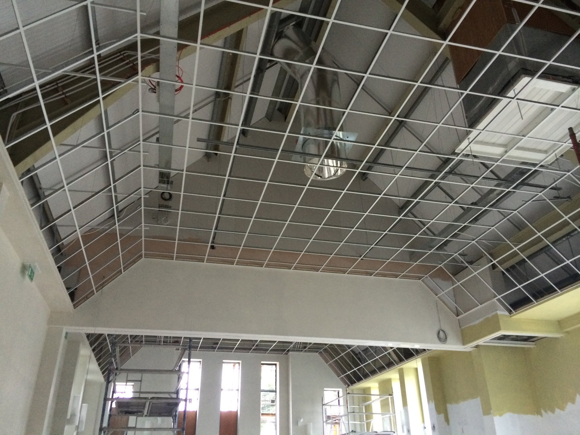 Acoustical ceiling grid installation in progress